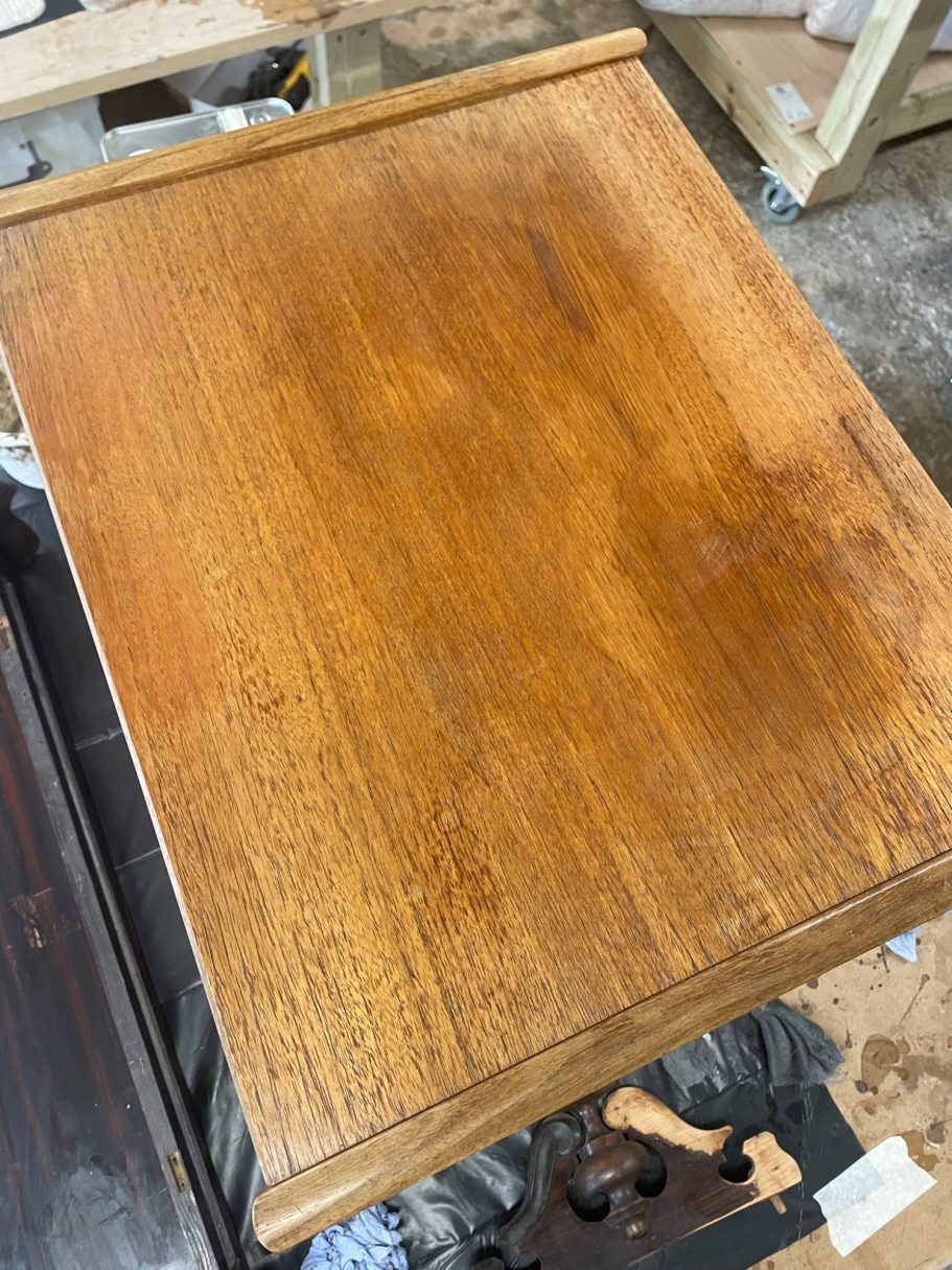 Biggest G Plan Table at the start A polished wooden table surface with visible grain and slight scratches.