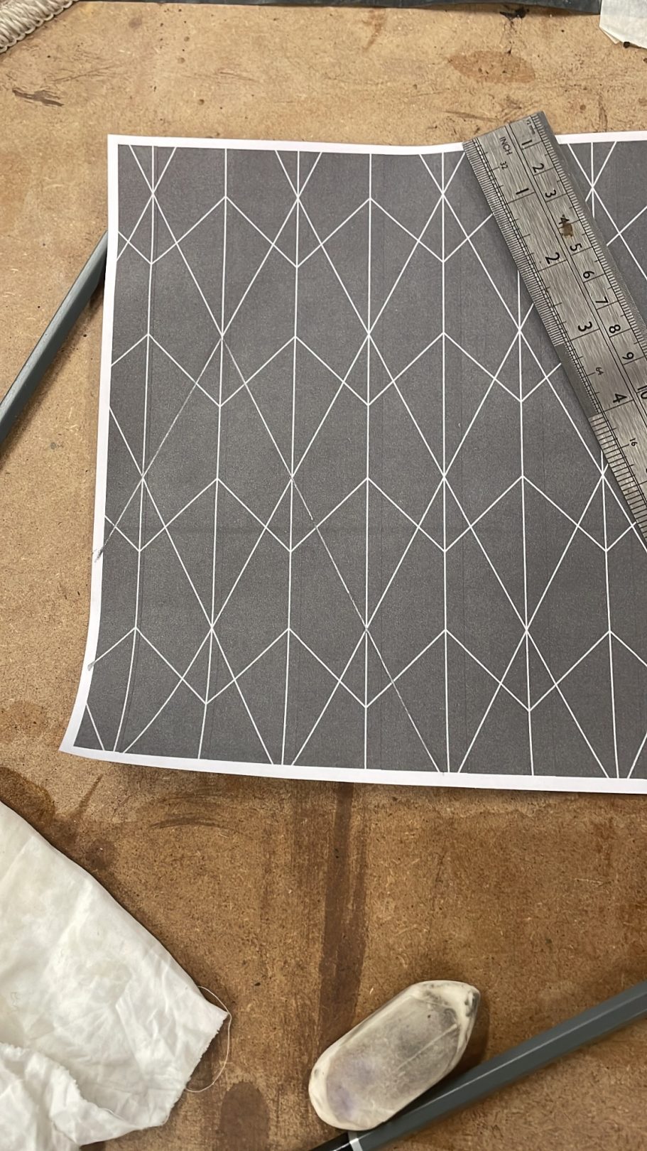 Creating the design Geometric pattern on grey background with drafting tools nearby.