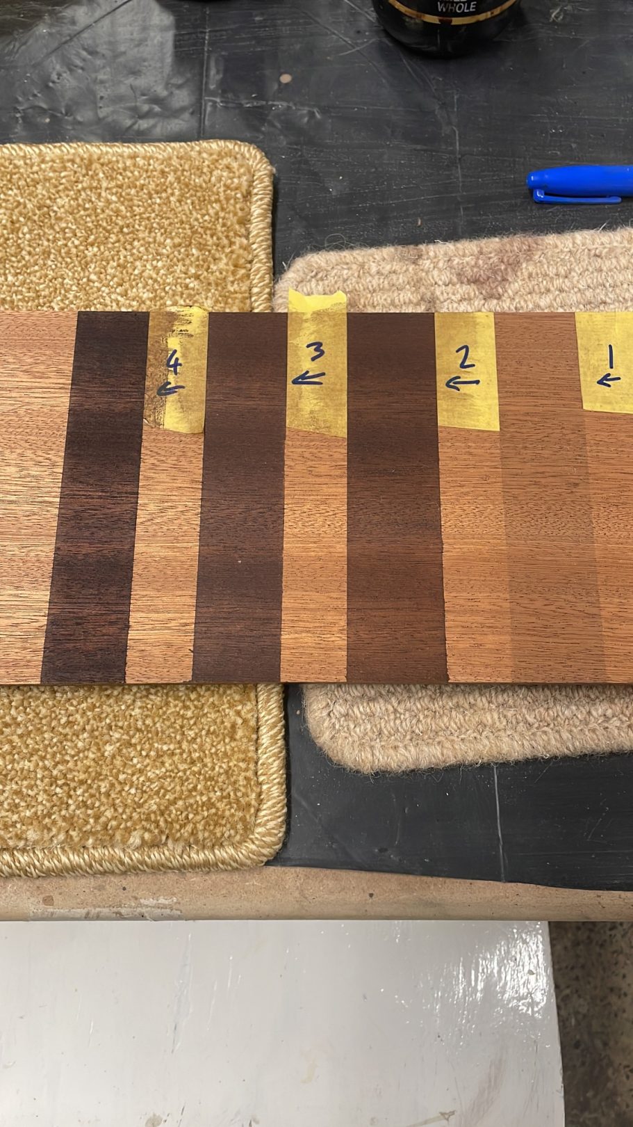 Choosing the stains Wood veneer samples in various shades lined up on a textured surface.