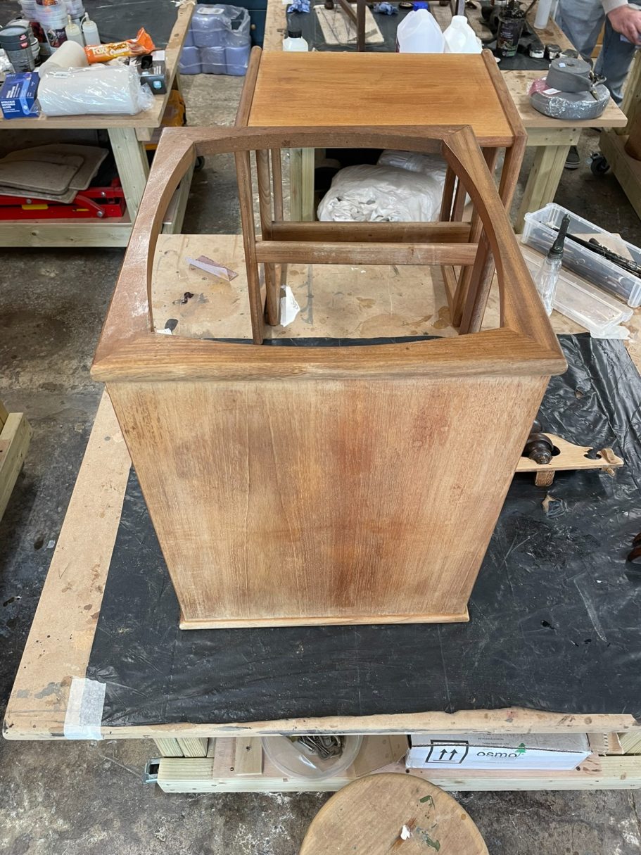Sanding the table Wooden furniture piece with an open top, displayed on a workbench.